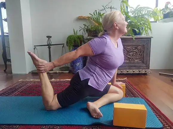 Mulher na maturidade praticando Yoga Personal em domicílio