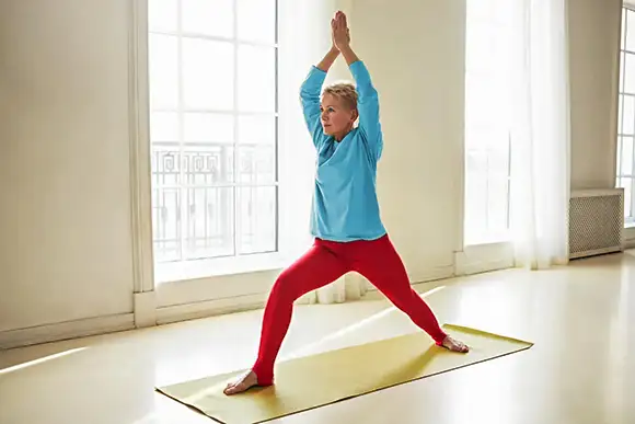Mulher na maturidade, praticando Yoga adequado à terceira idade